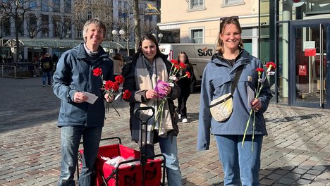 Michael Kaufmann (links), Svenja Püschel (rechts) und eine weitere, unterstützende Genossin waren mit einem kleinen roten Wägelchen in der Innenstadt unterwegs, um Flyer und Nelken zu verteilen.