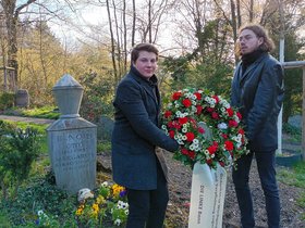 Andreas Darstar (Kreissprecher) und Hendrik Schlüter (Redner) präsentieren am Grab von Otto Renois in Poppelsdorf einen Kranz zum Gedenken an seinen 90. Todestag.