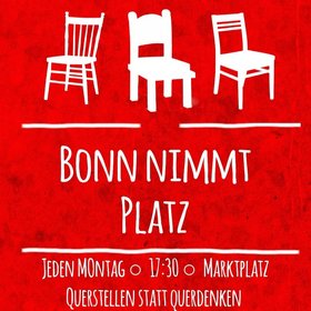 Drei weiße Stühle auf rotem Hintergrund mit der Unterschrift "Bonn nimmt Platz": Gegendemo gegen Querdenken