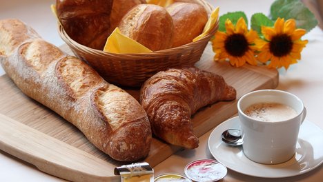 Frühstückstisch mit Brötchen und Kaffee