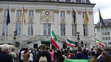 Teilnehmende der Kundgebung von hintern vor dem Alten Rathaus auf dem Bonner Marktplatz mit zahlreichen Iran-Flaggen