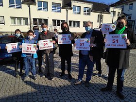 Arbeitskampf Uniklinik Bonn: Demonstrierende halten Schilder hoch und weisen damit auf das 100-Tage-Ultimatum hin.