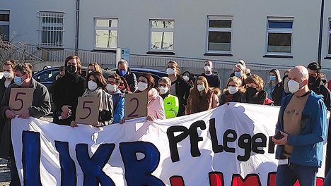 Arbeitskampf Uniklinik Bonn: Demonstrierende hinter einem Banner